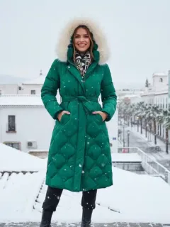 Mujer con abrigo Shein de invierno en paisaje urbano nevado en España, combinando estilo y calidez.