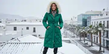 Mujer con abrigo Shein de invierno en paisaje urbano nevado en España, combinando estilo y calidez.
